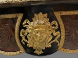 a gold and black table with a lion head on it