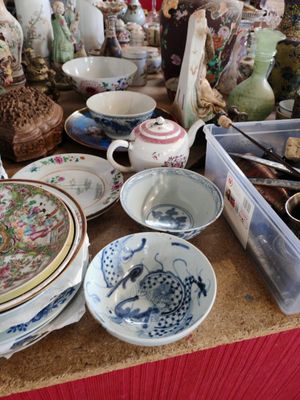 une table sur laquelle sont disposées de nombreuses pièces de vaisselle en porcelaine