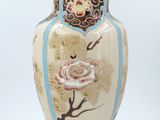 a vase with a rose on it sitting on a table