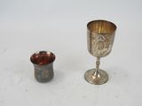 a silver goblet and a silver cup on a table