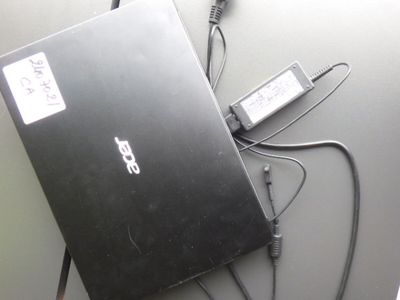 un ordinateur portable posé sur une table avec un chargeur