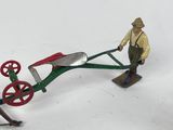 a small toy of a man pulling a wheelbarrow