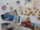 a lot of different coins and postcards on a table