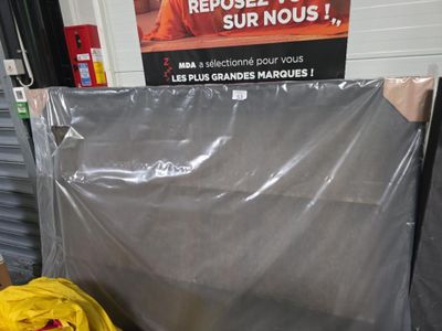 un tas de sacs en plastique posé par terre devant un panneau
