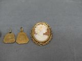 a close up of a gold plated broochle and two other items