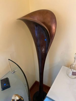 a glass table with a vase on it next to a lamp
