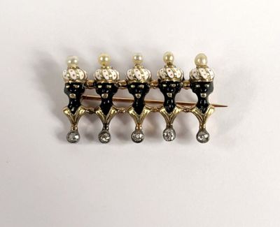 three gold and black pins with pearls on them sitting on a white surface