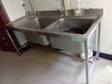 two sinks in the kitchen with a bottle of water on the counter