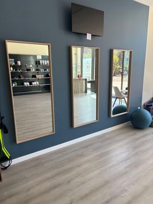 une photo d'une salle de sport avec des miroirs aux murs