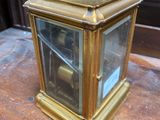 a gold clock sitting on a wooden table in a room