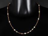 un collier à chaîne en or avec des perles sur un mannequin, un mannequin, un mannequin, un mannequin, un mannequin