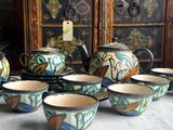 many cups and teapots sitting on a table