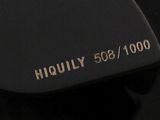 a close up of a black tie with a gold logo on it