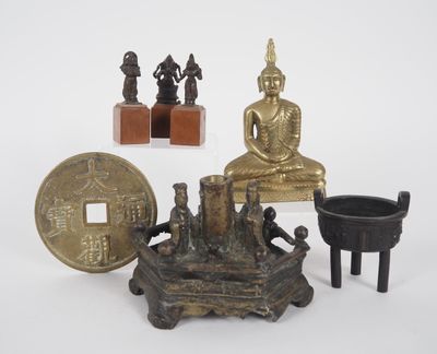 une petite statue de Bouddha posée sur une table, à côté d'autres objets