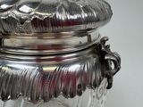 a glass jar with a silver lid on a table