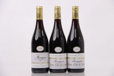 trois bouteilles de vin posées sur une table l'une à côté de l'autre