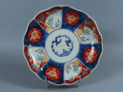 une image représentant une assiette bleue et blanche ornée de fleurs rouges
