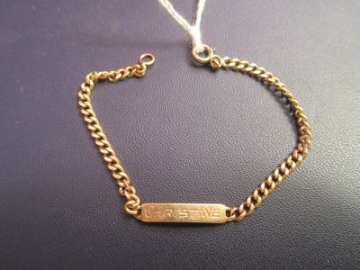 a close up of a gold bracelet on a black surface