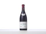 a bottle of red wine sitting on top of a white table