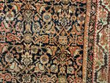 an antique persian rug with a floral design on a black ground