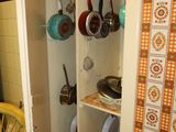 a cupboard with pots and pans on it in the kitchen