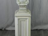 statue of a cat sitting on a pedestal with a cat on top of it