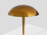 a gold table lamp on a white surface with a white background