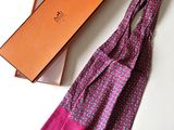 purple and pink scarf in a gift box next to a pink and orange bag