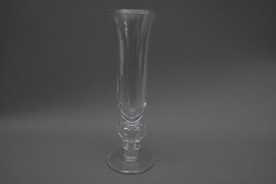 un vase en verre transparent posé sur une surface grise