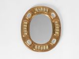 a gold mirror on a white wall with a white background