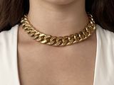 the woman is wearing a gold chain necklace and a white shirt