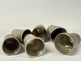 four silver thots sitting on top of each other on a white surface