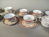 many cups and saucers sitting on a table