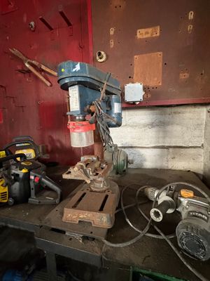 a drill on a workbench with tools on it