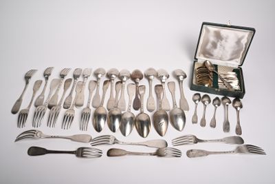 de nombreuses fourchettes et cuillères disposées sur la table