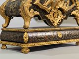 a gold and black clock sitting on top of a table