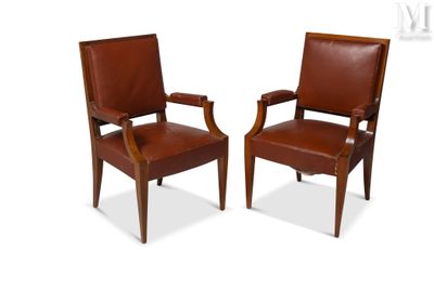 two brown leather chairs with wooden arms and arms