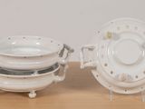 two white dishes sitting on a wooden table