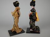 pair of japanese geisha figurines of a woman and a man with a fan
