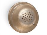 a metal strainer with holes in it on a white surface