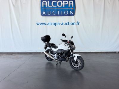 une moto blanche garée devant un mur blanc