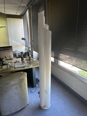 une grande lampe posée à côté d'un bureau