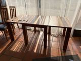 a wooden table and two chairs on a tiled floor