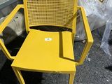 une chaise jaune posée devant une fenêtre