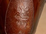 a close up of a brown vase on a table