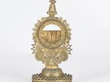 a gold plated candle holder with a crown on top of it