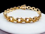 bracelet plaqué or à maillons et fermoirs, monté sur un socle blanc