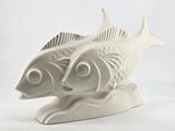two white fish that are sitting on a white surface
