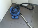 un aspirateur bleu et noir posé par terre à côté d'un seau bleu