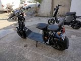 a scooter that is parked next to a parked motor scooter